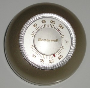 Figure 1. A familiar example – the round mechanical thermostat. Credit: <a title="Honeywell thermostat" href="https://commons.wikimedia.org/wiki/File:Honeywell_thermostat.jpg" target="_blank">Vincent de Groot / Wikimedia Commons, CC BY 2.5</a>.